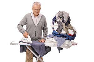 senior man ironing clothes as non-exercise activity