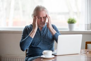 Senior man struggling at computer with memory and learning